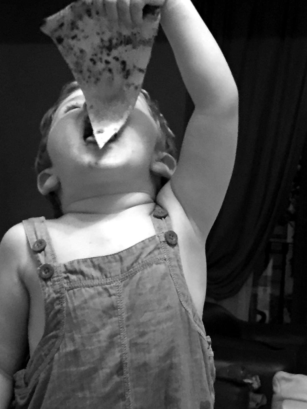 Nanni, el pequeño de la casa, comiendo una porción de pizza